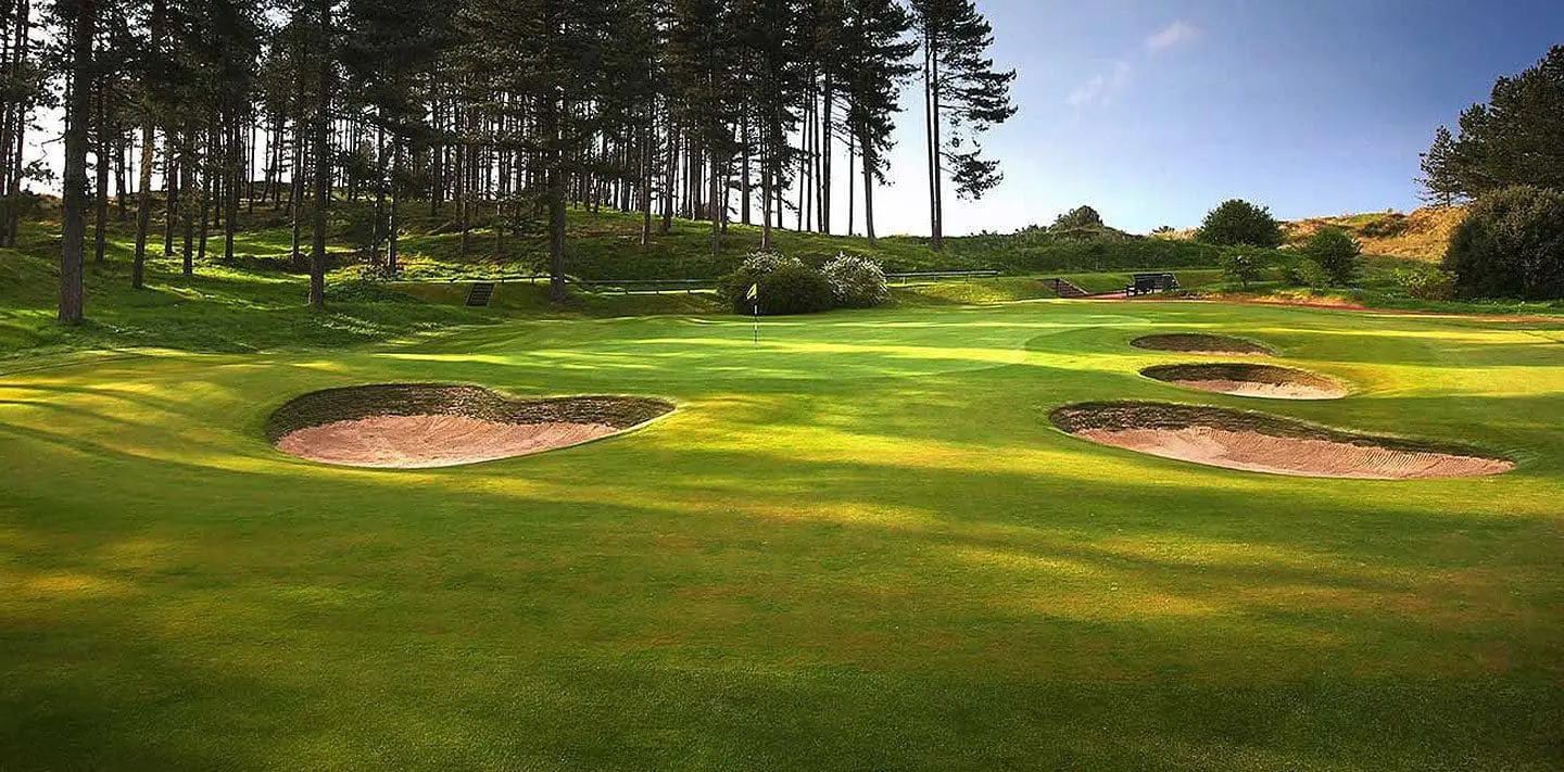 Bunkers and green framed by pines at Hillside Golf Club